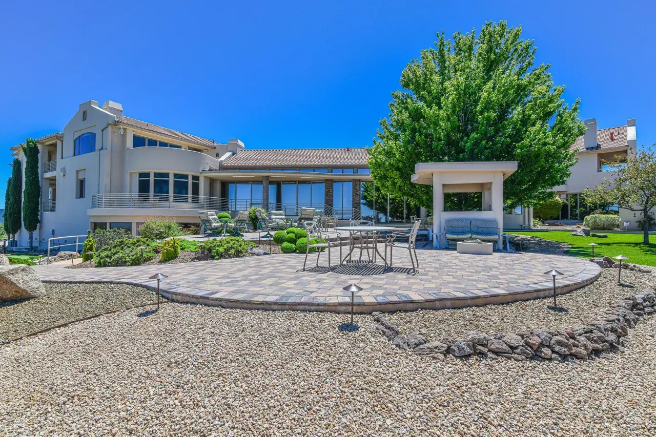 Luxury outdoor living space by a custom home builder in Prescott AZ with patio seating and landscaped yard